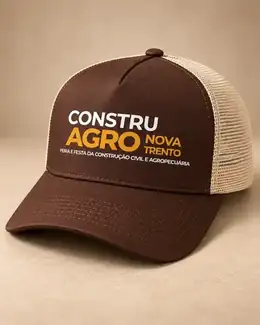 Boné trucker marrom com tela bege e personalização frontal Constru Agro em foto tratada para apresentação